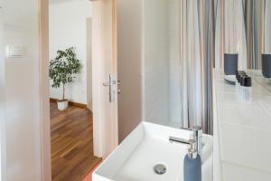 baño con lavabo blanco y planta en Vinařství & Vinařský dům Petratur, en Blatnice