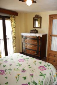 a bedroom with a bed and a dresser and a mirror at CASA FAÑETE in Ruguilla
