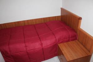 a small bed with a red cover in a room at Residence Hotel Torresilvana in Vieste