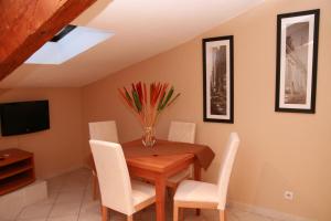 a dining room with a wooden table and white chairs at Cannes Loft Alexander in Cannes