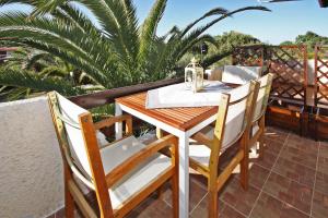 a wooden table and chairs on a balcony at Villa Angela in Vourvourou