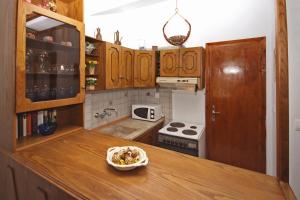 a kitchen with wooden cabinets and a bowl of food on a counter at Villa Angela in Vourvourou