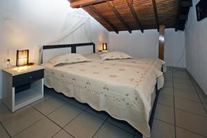 a bedroom with a bed and a table with lamps on it at Villa Angela in Vourvourou