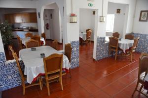 una sala da pranzo con tavoli e sedie e una cucina di Horta D'Alva a Castelo Branco