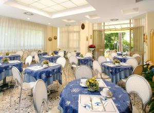 リッチョーネにあるHotel Cristinaの青いテーブルと白い椅子が備わる宴会場
