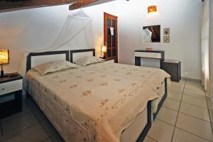 a bedroom with a bed and two tables and a lamp at Villa Angela in Vourvourou