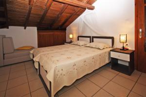 a bedroom with a large bed and a chair at Villa Angela in Vourvourou