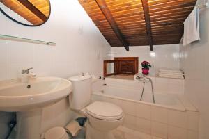a bathroom with a toilet and a sink and a tub at Villa Angela in Vourvourou