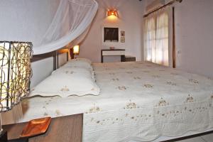 a bedroom with a large white bed with a window at Villa Angela in Vourvourou