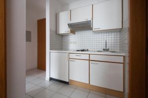 una cucina con armadi bianchi e lavandino di Appartements Christophorus a Bad Hofgastein