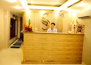 a man standing behind the counter of a restaurant at New Sunny Hotel in Ho Chi Minh City