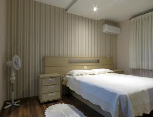 1 dormitorio con cama, lámpara y ventilador en Condado De Rosenfeld, APARTAMENTO EXCLUSIVO, COM 2 QUARTOS en Gramado
