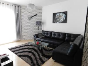 - un salon avec un canapé en cuir noir et une table en verre dans l'établissement Avrora Luxury Apartment, à Ashkelon