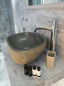 a large stone sink in a bathroom with four bottles at Drougas' Windmill in Plaka Milou +55 photos