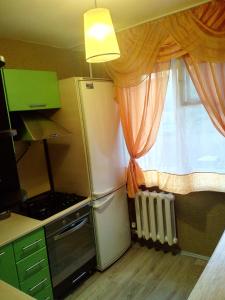 SalavatにあるАпартамент Нефтяникの小さなキッチン(冷蔵庫付)、窓が備わります。