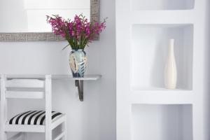 un vaso con fiori viola su un tavolo con una sedia di Bungalows Marina a Naoussa