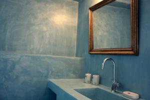 a blue bathroom with a sink and a mirror at Bungalows Marina in Naousa