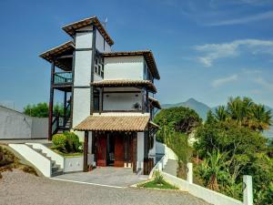 a house with a tower on top of a hill at Pousada Kaya in São Sebastião