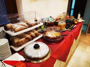 un buffet con bollería y otros alimentos en una mesa roja en Hotel La Giara, en Cefalú