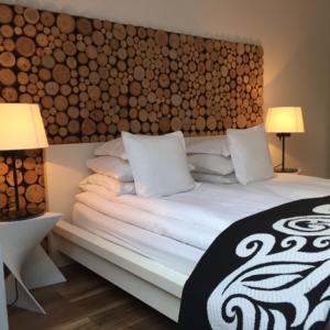 a bedroom with a large bed with a wooden headboard at Kamienica Nadmorska in Jastarnia