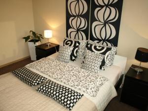 ポズナンにあるQuiet-Apartments Długoszaのベッドルーム1室(大型ベッド1台、白黒の枕付)