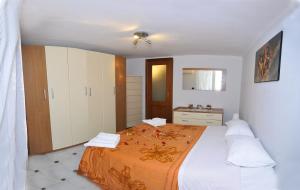 - une chambre avec un grand lit et une couverture orange dans l'établissement Welcome House, à Naples