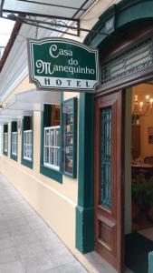 een restaurant met een bord aan de zijkant van een gebouw bij Casa do Manequinho Hotel e Restaurante in Piraí