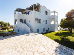 ein großes weißes Haus mit einer großen Terrasse in der Unterkunft Evi Rooms in Aliki