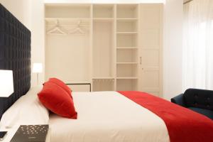 a bedroom with a white bed with red pillows at AiA EXCLUSIVE APARTMENTS in Granada