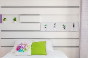 una camera con un letto bianco e un cuscino verde di Casa dos Avós by Rent2U, Lda a Funchal