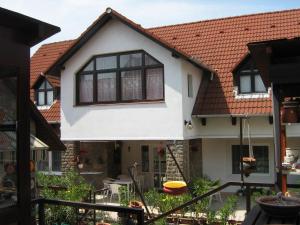 a white house with a red roof at Oleander Vendégház in Tihany