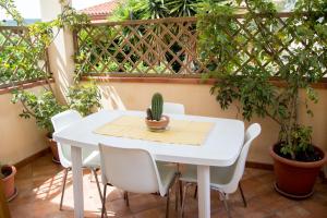 a white table and chairs on a balcony with plants at Casa Fertilia in Fertilia