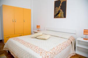 a bedroom with a bed and yellow cabinets at Casa Fertilia in Fertilia