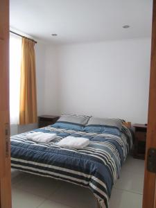 a bed with two pillows on it in a room at Hostal Balmaceda in Punta Arenas