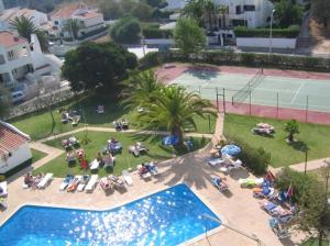 un gruppo di persone seduti su sedie a sdraio accanto alla piscina di Apartamentos Turisticos Silchoro ad Albufeira