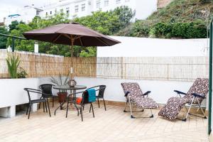 a patio with a table and chairs and an umbrella at Casa Las Nieves in Arcos de la Frontera