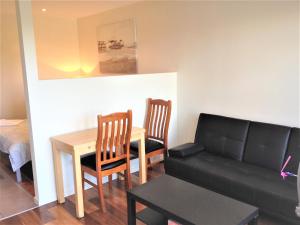 a living room with a table and a couch at Glen Waverley Apartment in Glen Waverley