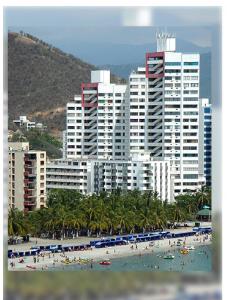 a beach with a bunch of people and buildings at Rivas Apartamentos Santa Marta in Santa Marta