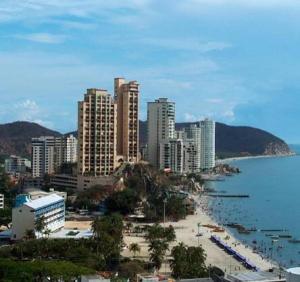 een stad met hoge gebouwen en een strand aan het water bij Rivas Apartamentos Santa Marta in Santa Marta