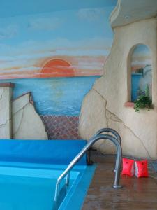 a swimming pool with a painting on the wall at Märchenhotel Waldpension Nebelstein in Harbach