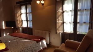 インフィエストにあるHotel Rural Casa Cuetoのベッドルーム1室(ベッド1台、椅子、窓付)