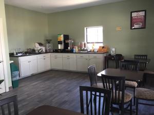 a dining room with a table and chairs and a kitchen at Americas Best Value Inn-Norman in Norman