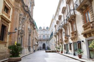 an empty street in a city with buildings at NoMapartments Il Cortile Romey in Trapani