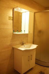 a bathroom with a sink and a mirror and a shower at Holiday Summerland Apartment in Mamaia