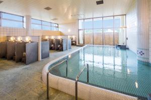 a large swimming pool in a building with windows at Art Hotel Ishigakijima in Ishigaki Island