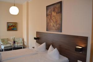 a hotel room with a bed and a painting on the wall at Hotel am Landeshaus in Wiesbaden