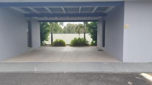 an empty parking lot with a white building at The Commercial Hotel Motel in Chinchilla