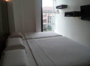 a bed in a room with a window at Dream Hotel in Klang