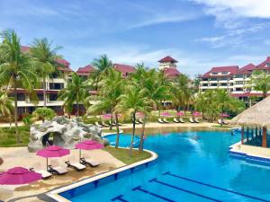 a resort with a swimming pool with chairs and umbrellas at Sand & Sandals Desaru Beach Resort & Spa in Desaru