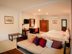 a living room with a bed and a couch at Tamali Hotel in Nakhon Si Thammarat